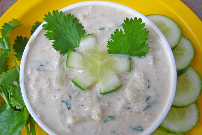 a bowl of Indian spiced yogurt with cucumber